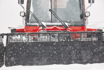 Snow blower truck covered by snow. Winter time. Snowing