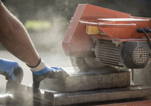 Workman cutting using an angle grinder